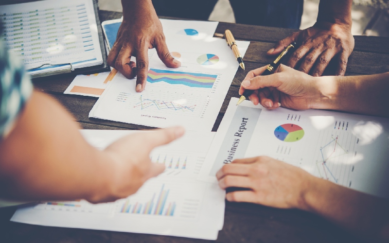 SEO experts analyzing business reports and marketing data to plan targeted campaigns for qualified audience growth.